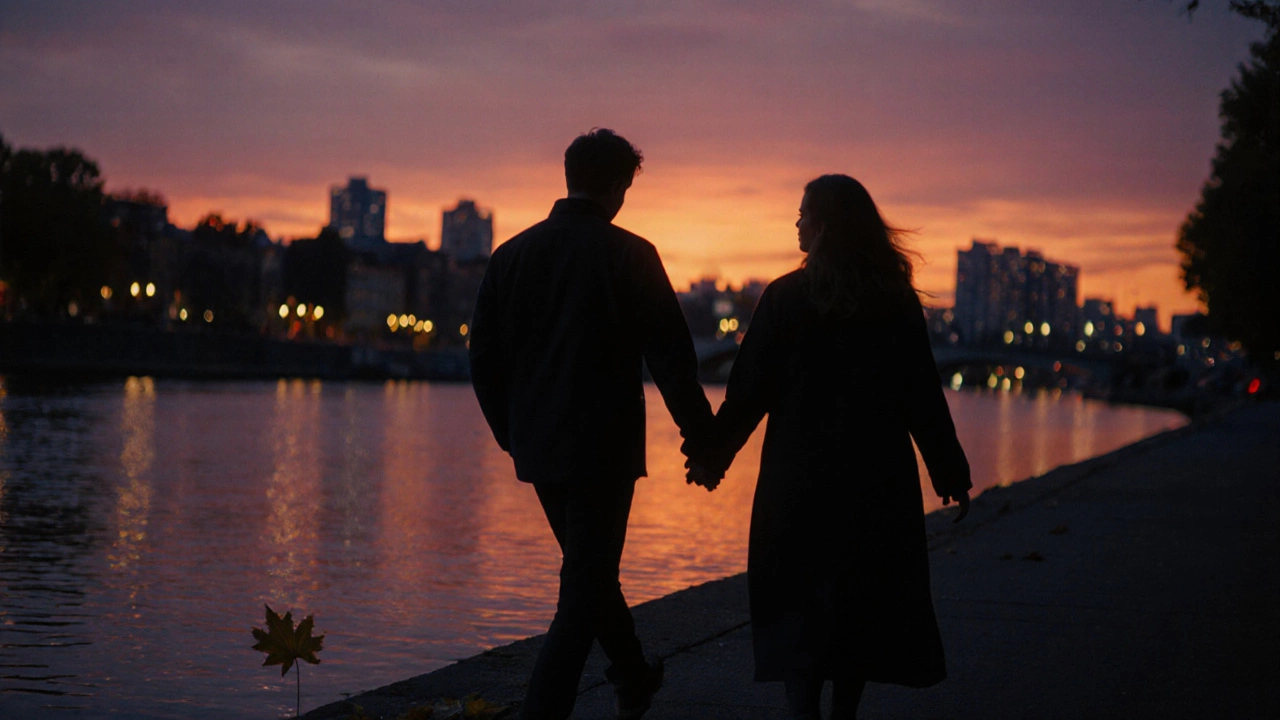 Двое гуляют по набережной на закате, руки слегка соприкасаются.