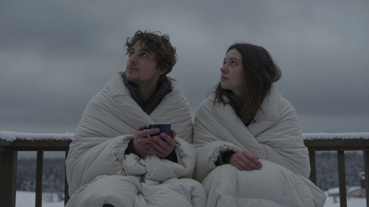 Двое сидят на балконе под пледом, смотрят в зимнее небо, затянутое облаками.