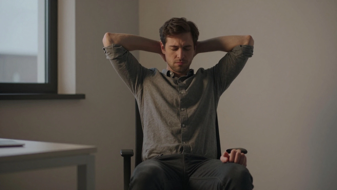 Мужчина в офисе с напряженными плечами и одной сжатой рукой, вечерний свет.