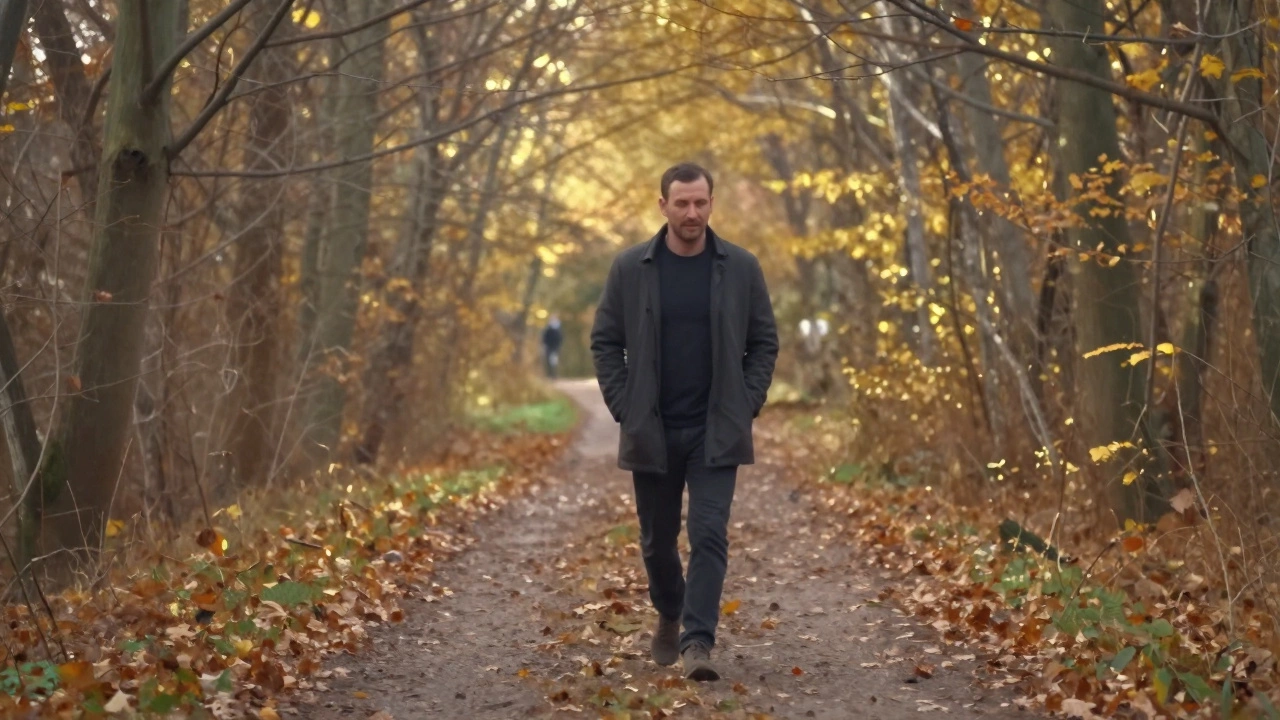 Мужчина спокойно гуляет по осеннему лесу без телефона, листья шелестят под ногами.